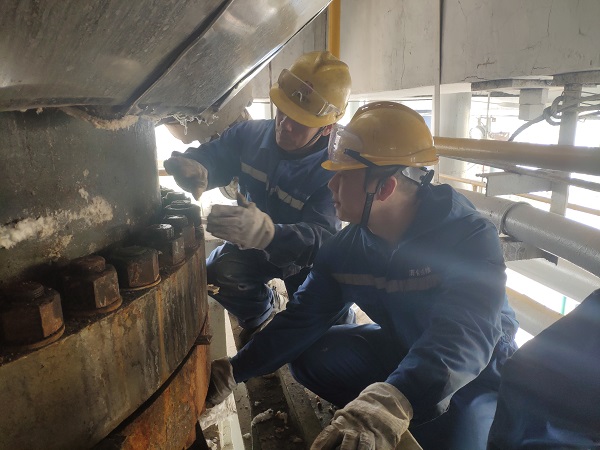 4月6日，機械修造部檢修二部張振華、盧超逸在檢修平臺處，進行4號氣化爐破渣機下降管短節(jié)法蘭螺栓的拆卸工作。.jpg
