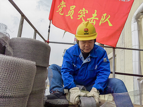 5月10日中午，在動力車間三期工藝除氧器平臺上，黨員突擊隊隊長李鑫正在纏繞新填料.jpg