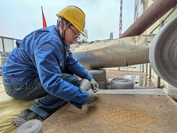 5月10日中午，在動力車間三期工藝除氧器平臺上，黨員突擊隊隊員劉瑞斌正在纏繞新填料.jpg