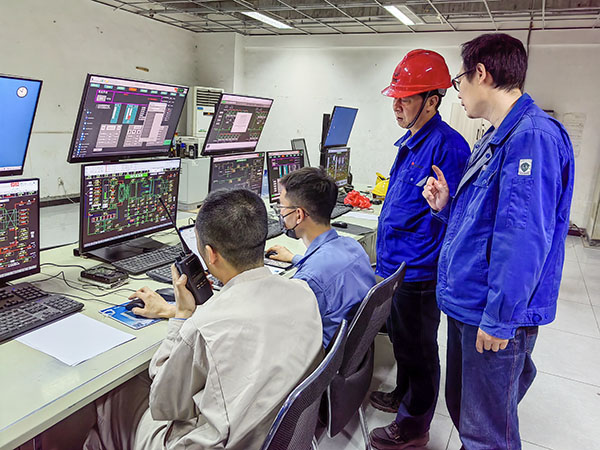 5月13日，動力車間三期鍋爐控制室，DCS改造工藝、儀表、電氣等部門聯(lián)合調(diào)試，車間主任姜軍虎與技術(shù)員畢加佳查看調(diào)試過程.jpg