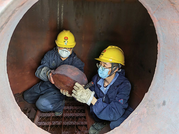 5月11日，動力車間三期工藝除氧器內(nèi)部，黨員突擊隊(duì)隊(duì)員劉瑞斌和李震正在清理舊填料.jpg