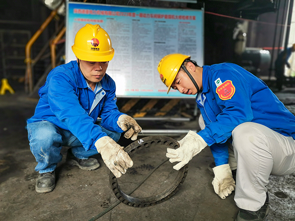 圖三：12日下午14時，在一期磨煤機廠房，陜西省技術(shù)能手姬霄給青工張跟潮講解磨煤機搖臂曲拐內(nèi)環(huán)及動作原理。.jpg
